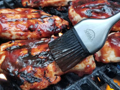 Bbq chicken on the grill with the SpitJack Silicone & Stainless BBQ Brush Set from SpitJack.
