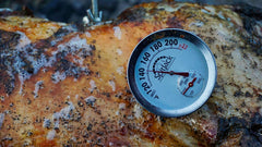 A SpitJack Dual Sensor Meat and Oven Thermometer (2 Pack) is placed on a piece of meat.