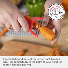 A person uses a red KUHN RIKON Original Swiss Peeler from the 3-pack (which includes red, green, and yellow peelers) with a carbon steel blade to peel a carrot. The text on the image describes the Kuhn Rikon peeler as featherlight, suitable for both left and right-handed use, and comfortable to hold.