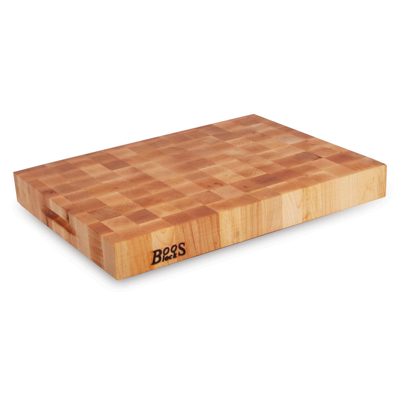 The John Boos Boos Block CCB Series Large Reversible Wood Chopping Board, featuring a 2.25-inch thickness and dimensions of 20" x 15" x 2 1/4", is crafted from maple wood. This rectangular board, branded with the iconic Boos Block logo on one side, offers a patterned surface and a handle groove on the shorter end, making it perfect for your kitchen or elegant gatherings.