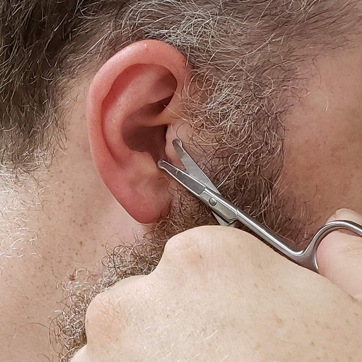 A person carefully trims their ear hair using the safe SpitJack Utility Mini Scissors (4 Inch Stainless Steel) 2 Pack.